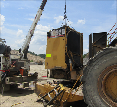 Accident scene where a contract mechanic field technician was fatally injured while removing the radiator guard from a front-end loader when the counterweight fell on him. 
