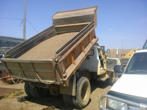 The dump truck with its bed shown in the raised position.