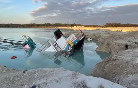 Accident scene where two contractors died when the dragline they were operating slid into a water-filled pit.