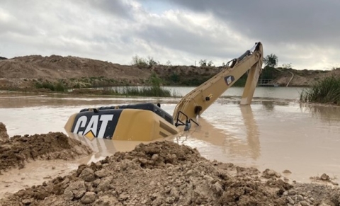 Accident scene where a miner drowned when his excavator traveled over a berm into a sediment pond.