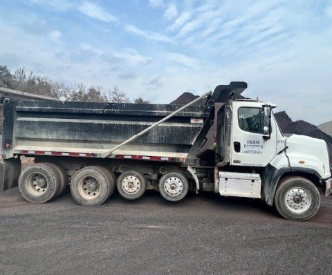 Accident scene where an over-the-road truck driver died after he became pinned between the dump bed and the frame of a truck.