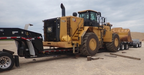 Accident scene where a contract truck driver died while loading a front-end loader onto a trailer for transportation.