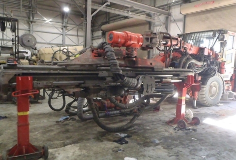 Accident scene where a contract mechanic died after the boom of a drill mast rolled, struck, and pinned him.