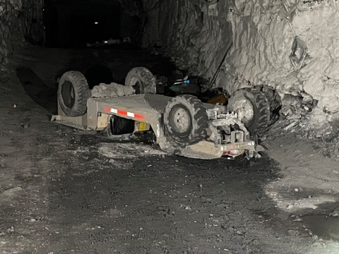 Accident scene where a miner died when the personnel carrier he was riding overturned. Another miner riding on the personnel carrier accidentally actuated the emergency stop causing the personnel carrier to drift backwards down a grade.
