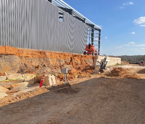 Accident scene where a contractor died while working in an excavated area when the adjacent concrete block retaining wall collapsed.