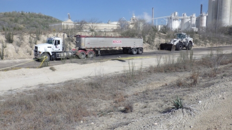 Accident scene where a truck driver died when the tractor’s rear wheels ran over him.  A front-end loader struck the tractor-trailer from behind, causing the tractor to move forward.