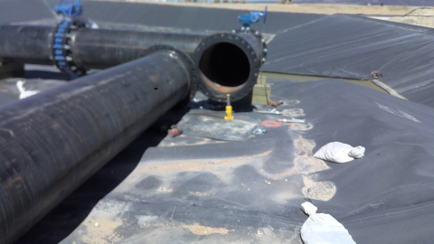 Accident scene where a contract miner died while attempting to bolt two 30-inch diameter steel pipes together at a pond pad construction area.