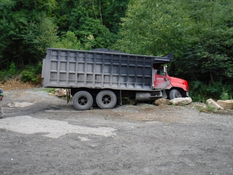 accident scene where a 53-year-old contract truck driver with ten years’ experience was fatally injured while conducting a pre-operational examination of a truck.