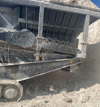 Accident scene where a miner was fatally injured when he became entangled in the return idler on the belt conveyor under a portable crusher plant. 