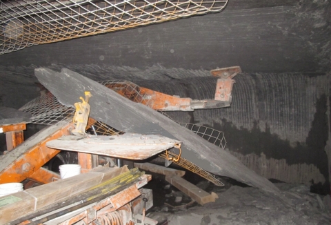 Accident scene where a 29-year-old roof bolter helper with 3 years and 48 weeks of mining experience was killed when a piece of rock approximately 3 feet wide, 11½ feet long, and 3 to 16 inches thick fell and pinned him against the top of the drill canopy of a roof bolting machine.