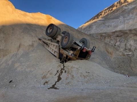 Accident scene where a miner backed a haul truck to the edge of a dump point that was over steepened by a loader removing material at the bottom of the slope.