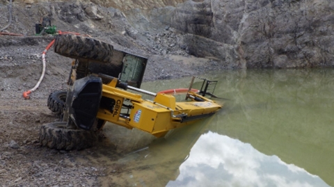 Accident scene where a miner died after the telehandler that he had been operating overturned onto him while he was outside the equipment moving a water pump suction line. 