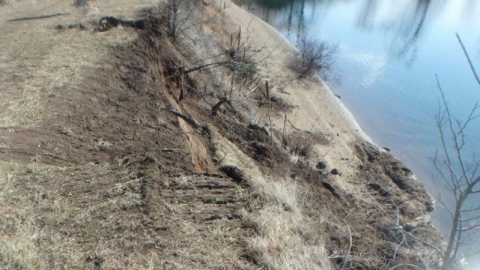 Accident scene where a miner was fatally injured when the excavator he was operating rolled over into a body of water.