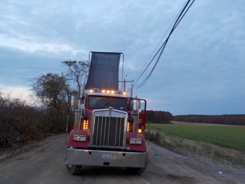 Accident scene where a customer truck driver was electrocuted after the tarping mechanism on the trailer contacted a high voltage overhead power line.