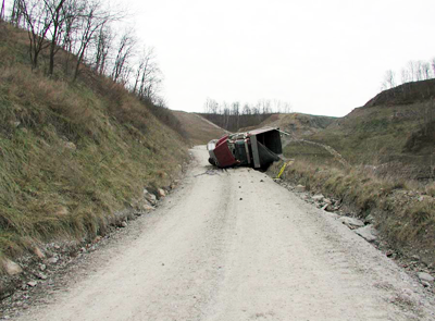 Accident scene where a 52-year old contract truck driver/mechanic, with 30 years experience, was fatally injured while driving a truck, loaded with coal, on a mine haul road.