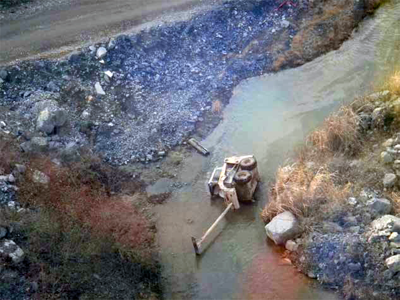 skid steer loader turned over in a ditch