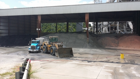 Wide angle of the accident site showing the positions of the truck and the front end loader. The truck is positioned with its rear facing the nearby ash mound for unloading and the loader has its rear diagonially against the truck