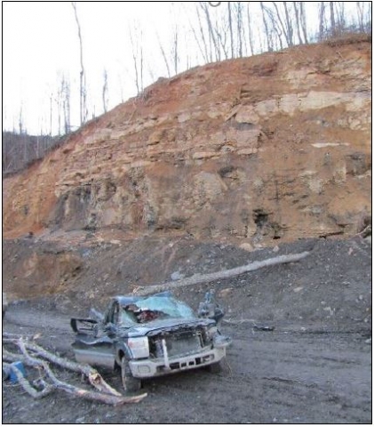 Accident scene where a 29-year-old roof bolter helper with 3 years and 48 weeks of mining experience was killed when a piece of rock approximately 3 feet wide, 11½ feet long, and 3 to 16 inches thick fell and pinned him against the top of the drill canopy of a roof bolting machine.