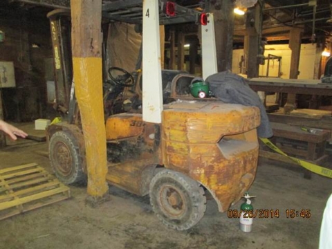 A forklift shown against a wooden support beam.