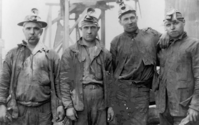 Historic scene showing four miners at the mine site