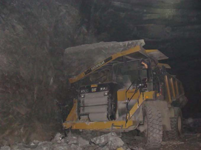 Haul truck covered in large fallen rock
