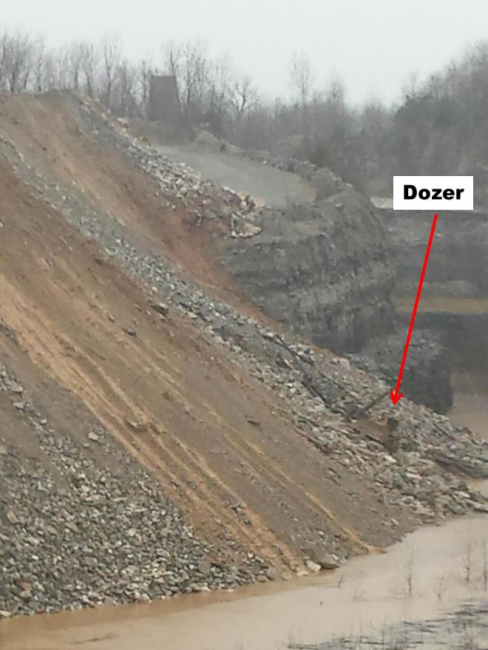 Bulldozer at bottom of embankment close to water