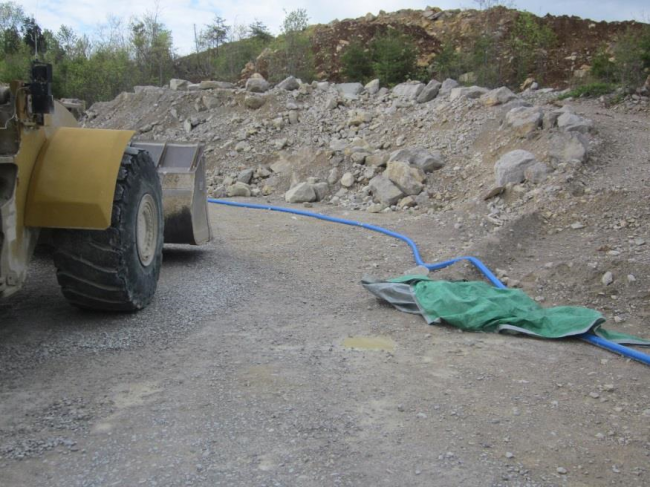 Corner of road with rocky ridge with loader