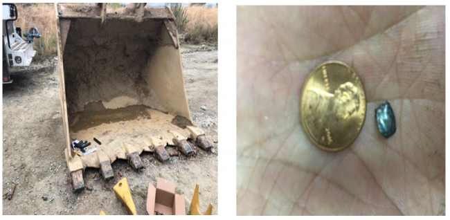 excavator bucket on left and small piece of metal smaller than penny on right